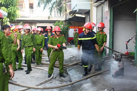 Bình gas rò rỉ, cửa hàng sắp khai trương phát hỏa ảnh 3 Cảnh sát đưa bình gas ra bên ngoài.