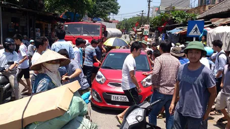 Chiếc xe ô tô bị người dân quây kín.