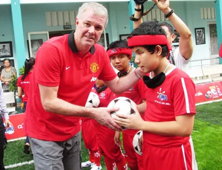 Cựu ngôi sao MU bất ngờ xuất hiện tại TPHCM ảnh 1 Gary Pallister (trái) trao quà cho trẻ em khiếm thị Việt Nam (ảnh: Quốc Anh)