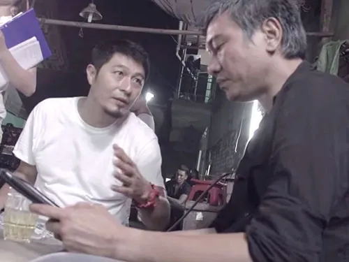 Phim Bụi đời Chợ Lớn bị cấm phát hành là một vết đen trong sự nghiệp đạo diễn điện ảnh của Charlie Nguyễn. Trong ảnh: Charlie Nguyễn (áo trắng) chỉ đạo trên trường quay phim Bụi đời Chợ Lớn. (Ảnh cắt từ YouTube)