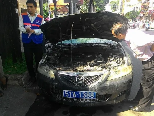 Thợ bảo trì đang xem máy móc trước đầu xe cháy đen.