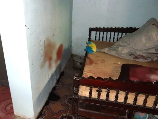 Chiếc gối và bức tường đẫm vết máu của nạn nhân