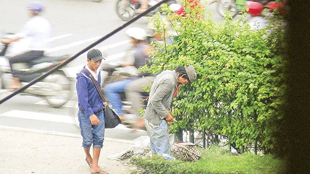 Người nghiện ngang nhiên tiêm chích ở chốn đông người (dải phân cách trên quốc lộ 22 đoạn gần ngã tư Trung Chánh, Q.12, TP.HCM)