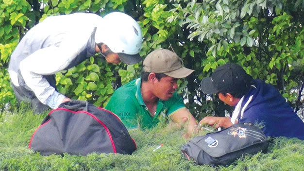 Người nghiện công khai tiêm chích cho nhau ở dải phân cách trên quốc lộ 22, đoạn trước khu vực bến xe An Sương (TP.HCM) - Ảnh: Khoa Long 