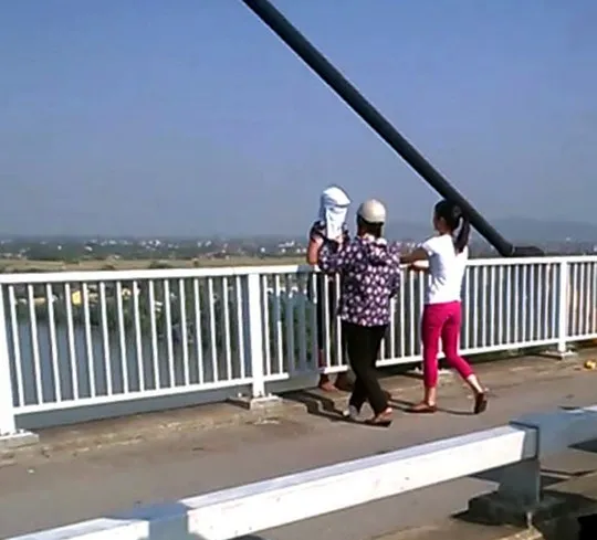 Chiến sỹ công an mặc thường phục tiếp cận người định nhảy cầu (ảnh cắt ra từ clip do người dân cung cấp)