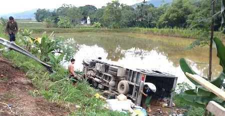 Chiếc xe tải chở hàng hoá nhu yếu phẩm lật xuống ruộng sau khi tránh xem máy kéo xe bò.