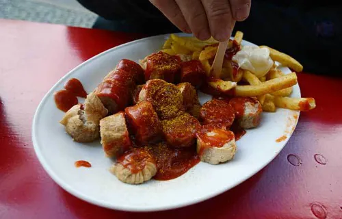 Xúc xích heo được nướng, hoặc hun khói, chiên lên. Sau đó cắt lát rưới nước xốt cà ri, tương ớt lên.