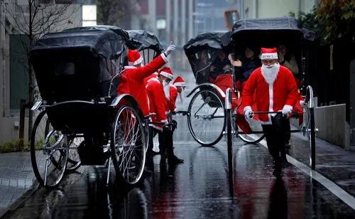 Khách du lịch đến Tokyo, Nhật Bản dịp Giáng Sinh có cơ hội đi xe kéo của các ông già Noel. Thực chất là việc đưa khách dạo qua các con phố là một phần việc trong sự kiện quảng cáo của công ty Smart&Co. Ảnh:AP. 1-Tokyo-1256-1419246161.jpg