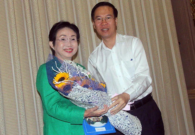 Ông Võ Văn Thưởng, phó bí thư thường trực Thành ủy tặng hoa cho phó giáo sư-tiến sĩ Trương Thị Hiền - Ảnh: Quang Khải