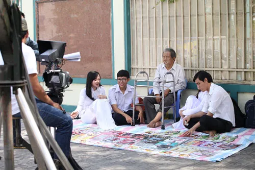 Mạc Can trong cảnh quay thể hiện nhân vật ông lão bán sách dạo trò chuyện cùng bạn trẻ. Một bạn trẻ đang say sưa với 'Kí ức chiến tranh' qua lời kể của nhân vật do Mạc Can thể hiện