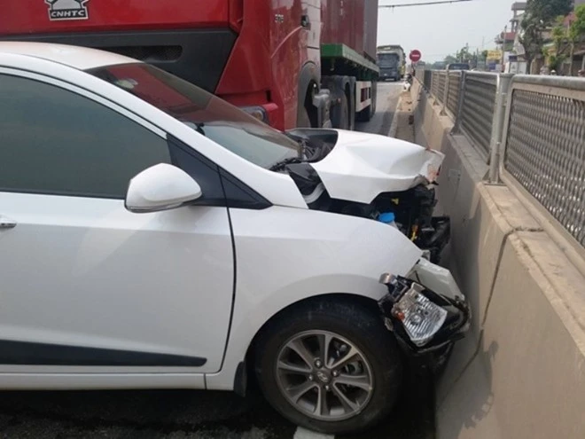 Đầu xe ôtô bị hư hỏng sau khi cạt vào giải phân cách giữa đường.