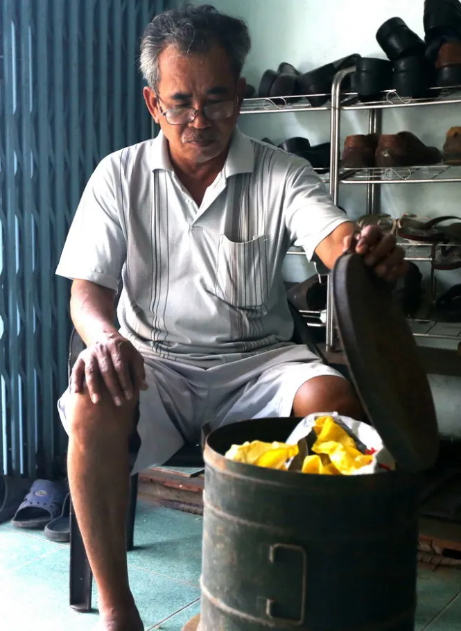 Ông Hải (nhân viên Sở Ngoại vụ TP.HCM) với thùng sắt đựng bo bo được giữ làm kỷ niệm: “Bo bo ăn thế nào ra thế đấy, nhưng nó đã cứu đói gia đình tôi” - Ảnh: Q.V.