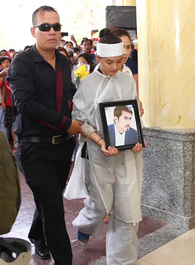 13h ngày 9/5, linh cữu người mẫu Duy Nhân được mang đến nghĩa trang Bình Hưng Hòa, TP HCM để thực hiện nghi thức hỏa táng. Trong ảnh: Kiều Oanh (phải) - vợ của nam người mẫu - ôm chặt di ảnh chồng cùng gia đình bước vào nơi làm lễ. Lễ tang Duy Nhân không kèn trống, mà diễn ra trong không khí trang nghiêm, lặng lẽ, thỉnh thoảng có tiếng khóc của người thân và bạn bè dành cho anh. kieu-oanh-om-anh-chong-3144-1431163433.j