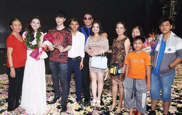 Bà ngoại (áo đỏ), cha mẹ (người đeo kính và người xách túi trắng) cùng họ hàng từ quê nhà An Giang lặn lội lên Sài Gòn cổ vũ cho Minh Như. Cô gái trẻ rạng ngời hạnh phúc chụp ảnh cùng Nathan Lee và người thân. Ảnh: ngoisao.net.