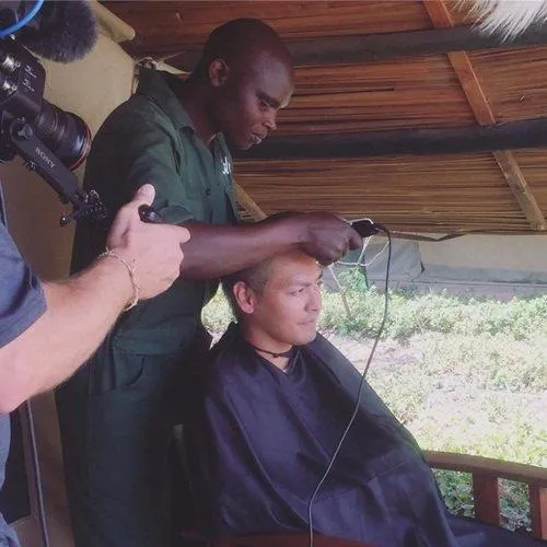 Các nhân viên trong chiến dịch bảo vệ động vật hoang dã tại Châu Phi giúp Phan Anh xuống tóc - Ảnh: NVCC