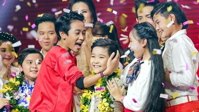 Trịnh Nhật Minh trong vòng tay của các thí sinh nhí thời khắc đăng quang ngôi vị quán quân. Ảnh DÂN TRÍ