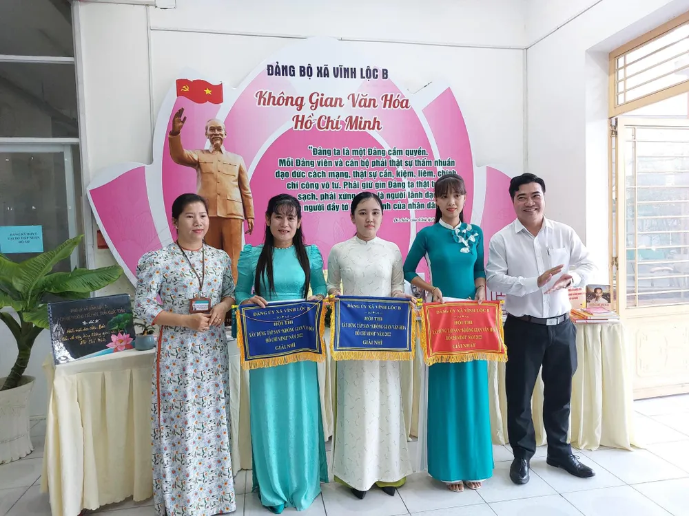 Tại buổi lễ ra mắt, ông Nguyễn Thành Nhân, Bí thư Đảng ủy xã Vĩnh Lộc B (bên phải) và bà Trần Thị Thái Nguyên, Chủ tịch UBND xã trao giải thưởng Hội thi xây dựng tập san “Không gian văn hoá Hồ Chí Minh” cho các đơn vị là các Chi bộ Trường học, các ấp trên địa bàn xã.