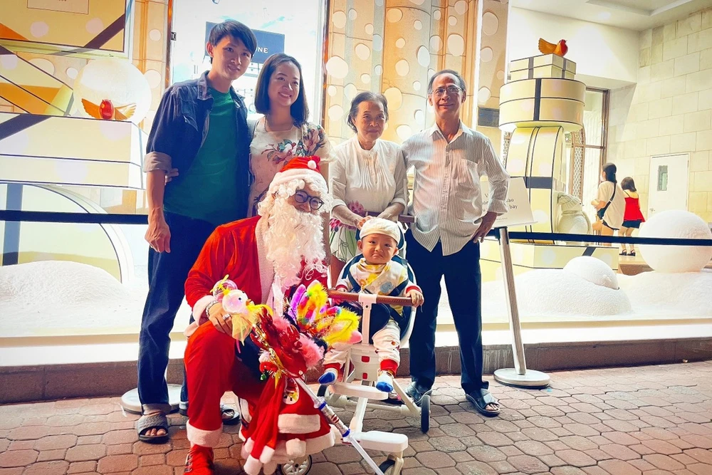 Một gia đình chụp ảnh chung với ông già Noel.Ảnh: TÚ NGÂN