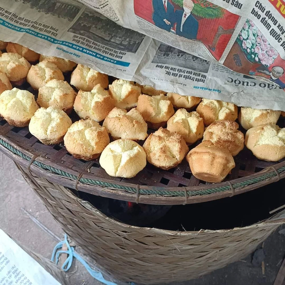 Bánh thuẫn lấy ra từ khuôn đặt trên nia che mấy tờ giấy báo để sấy dưới than lửa hồng cho thơm ngon và để được lâu hơn. Ảnh: NGUYỄN ĐƯỚC Bánh thuẫn lấy ra từ khuôn đặt trên nia che mấy tờ giấy báo để sấy dưới than lửa hồng cho thơm ngon và để được lâu hơn. Ảnh: NGUYỄN ĐƯỚC