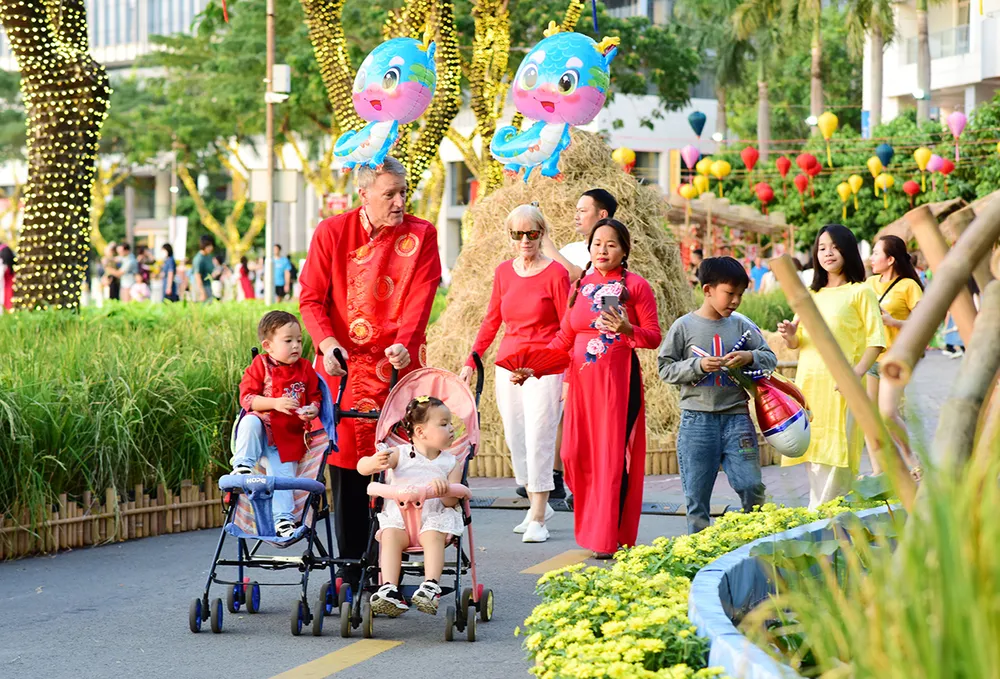 Du khách quốc tế mặc áo dài Việt Nam check-in tại Hội hoa xuân Phú Mỹ Hưng.JPG