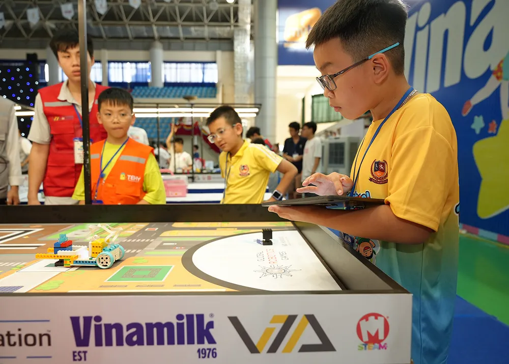 Thí sinh tập trung tìm giải pháp để robot thực hiện các thử thách trong đề thi. (Ảnh: Vi Nam) Vinamilk đồng hành cùng hơn 1500 tài năng trẻ cuộc thi Robotacon WRO 2024.JPG