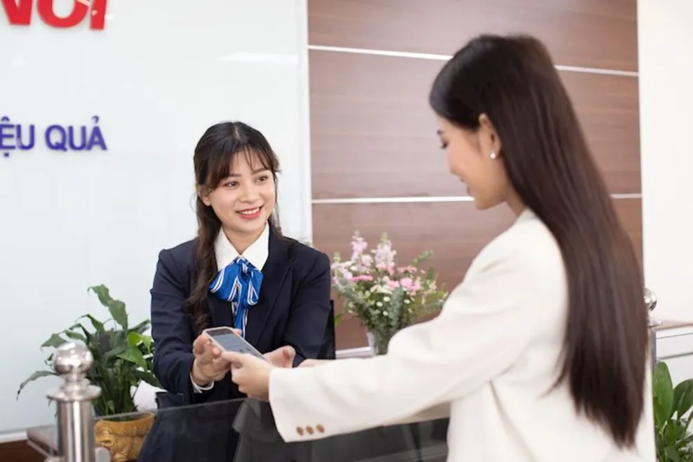 Nhân viên EVNHANOI hướng dẫn khách hàng thanh toán tiền điện không dùng tiền mặt. Điện lực Thủ đô ‘phủ sóng’ 100% khách hàng thanh toán tiền điện không dùng tiền mặt.jpg