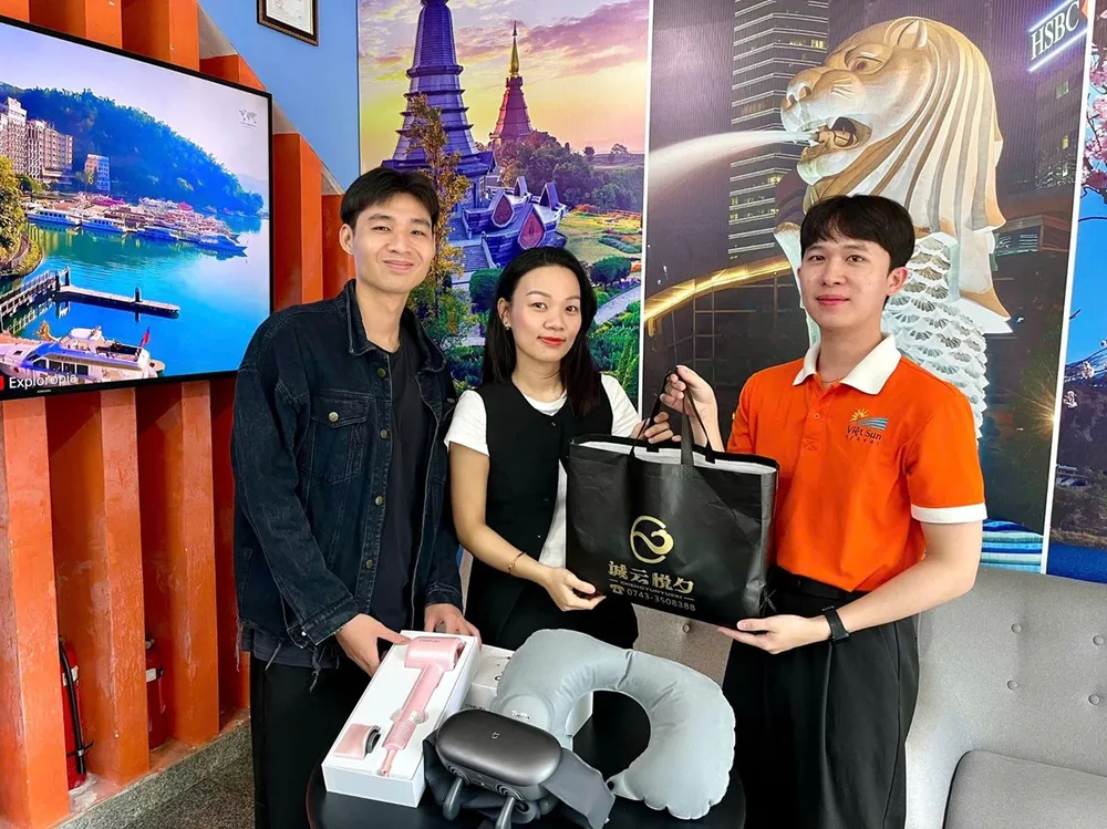 Khách hàng nhận quà tặng khi đăng ký tour Phượng Hoàng Cổ Trấn (Ảnh: Viet Sun Travel) Du lịch Việt Sun tặng quà độc quyền tour Phượng Hoàng Cổ Trấn.jpg
