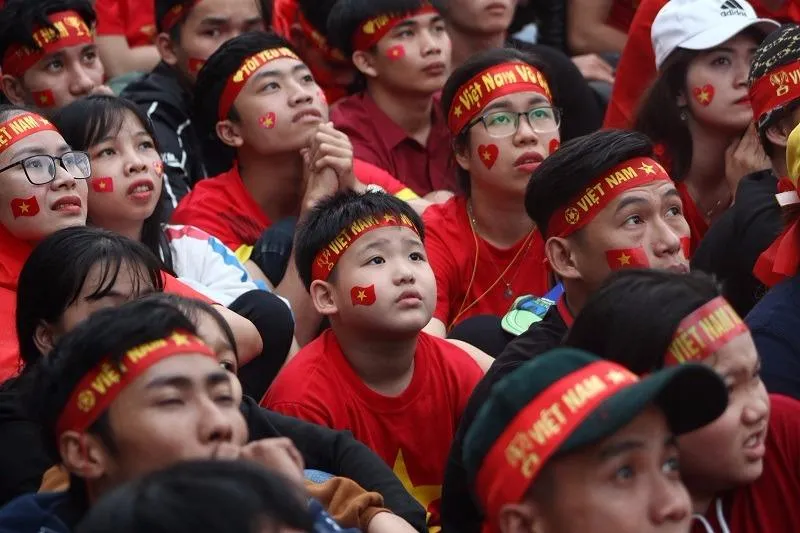 Các CĐV nhí được bố mẹ cho mặc bộ trang phục cờ đỏ sao vàng, đeo băng rôn, dán cờ trên má.