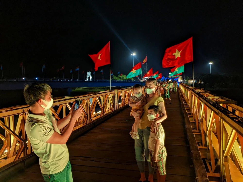 Du khách chụp ảnh lưu niệm trên cầu Hiền Lương. Ảnh: NGUYỄN DO