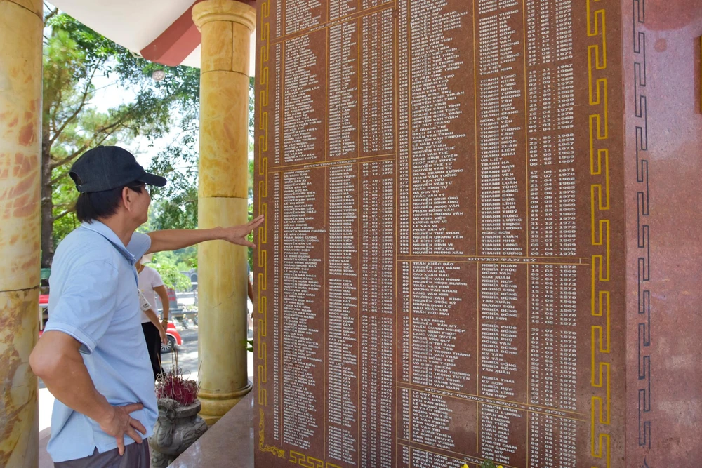 Những cựu binh dò tìm thông tin đồng đội trên những tấm bia đặt tại nghĩa trang. Ảnh: NGUYỄN DO