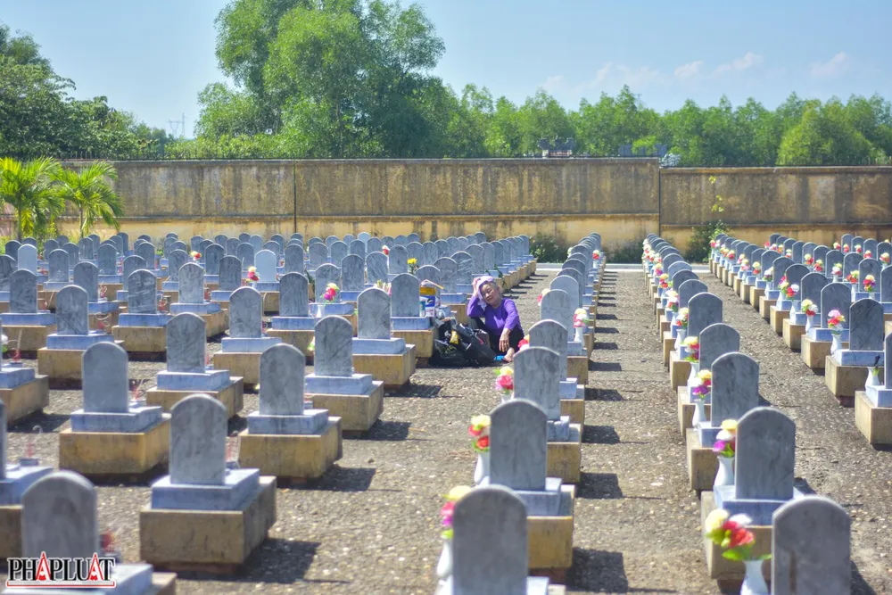 Dưới cái nắng như đổ lửa, người phụ nữ lớn tuổi dáng người lom khom ẩn hiện giữa hàng ngàn bia mộ, bà tìm đến một ngôi mộ và bật khóc nức nở. Bà là Nguyễn Thị Thuận, vợ liệt sĩ Nguyễn Văn Bảo (hi sinh vào năm 1972). Ảnh: NGUYỄN DO Dưới cái nắng như đổ lửa, người phụ nữ lớn tuổi dáng người lom khom ẩn hiện giữa hàng ngàn bia mộ, bà tìm đến một ngôi mộ và bật khóc nức nở. Bà là Nguyễn Thị Thuận, vợ liệt sĩ Nguyễn Văn Bảo (hi sinh vào năm 1972). Ảnh: NGUYỄN DO