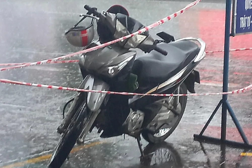 Chiếc xe máy của đối tượng Ngô Văn Quốc để lại trước cửa tiệm vàng ở chợ Đông Ba.