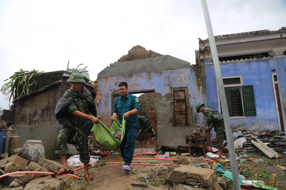 Lực lượng chức năng hỗ trợ người dân dọn dẹp nhà cửa. Ảnh: NGUYỄN DO