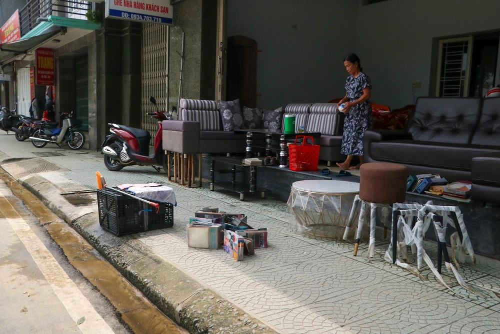 Người dân dọn dẹp hàng quán để sớm trở lại kinh doanh, buôn bán.