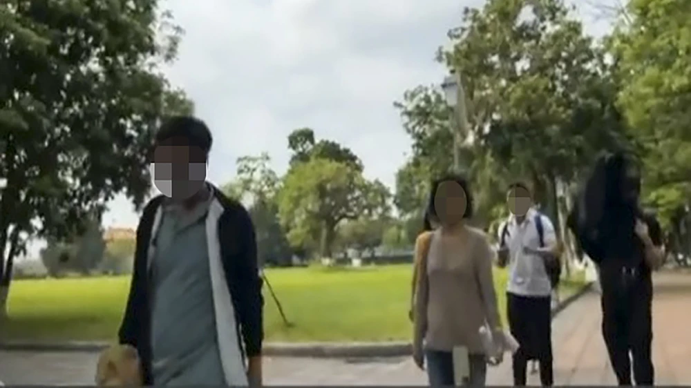 Hướng dẫn viên (áo trắng) hướng dẫn đoàn tham quan Đại nội Huế.