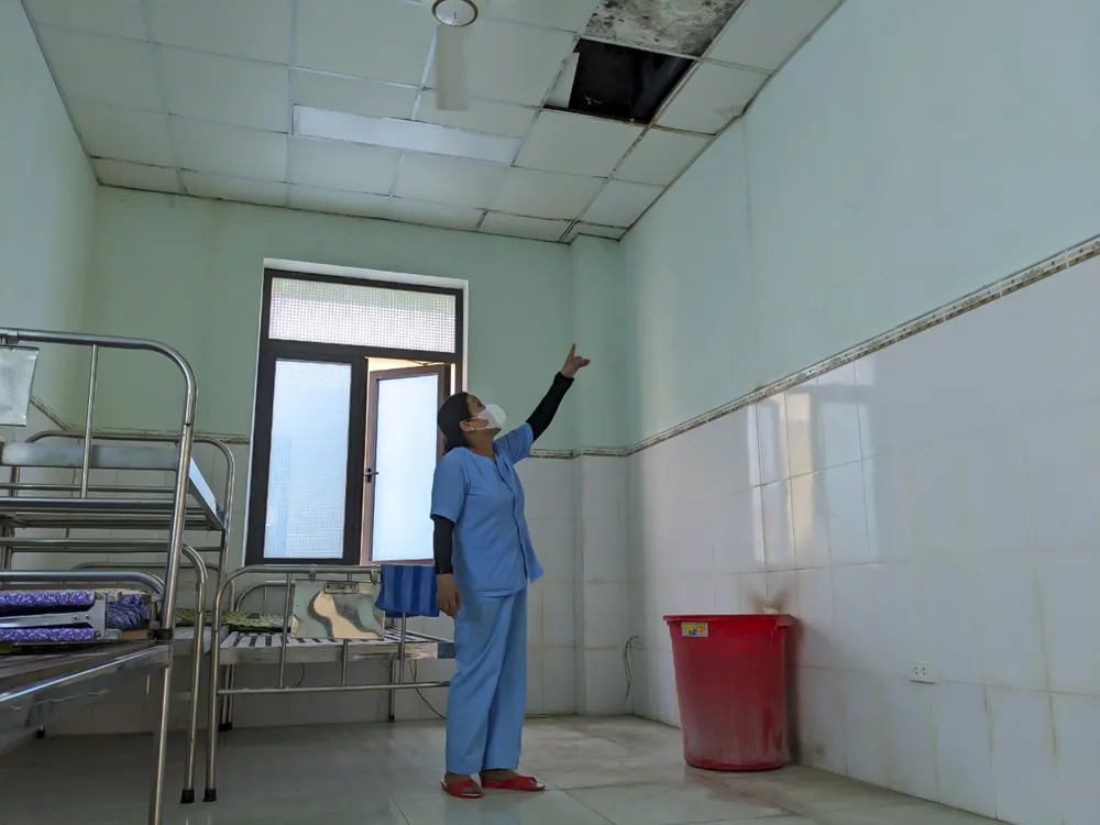 Nhân viên Bệnh viện đa khoa Triệu Phong cơ sở 2 phải dùng chậu hứng nước từ trần nhà. Ảnh: NGUYỄN DO