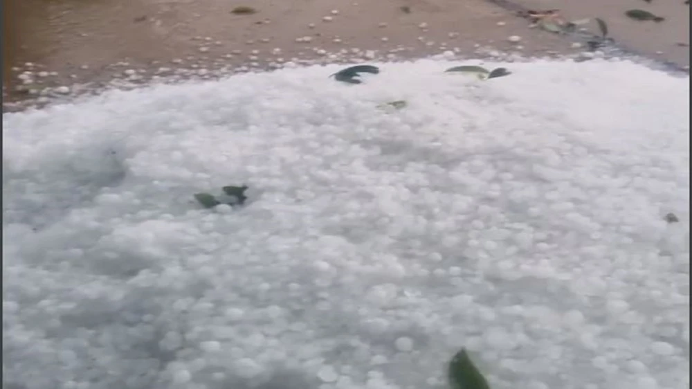 Người dân quét dọn mưa đá thành từng đống. Ảnh cắt từ clip