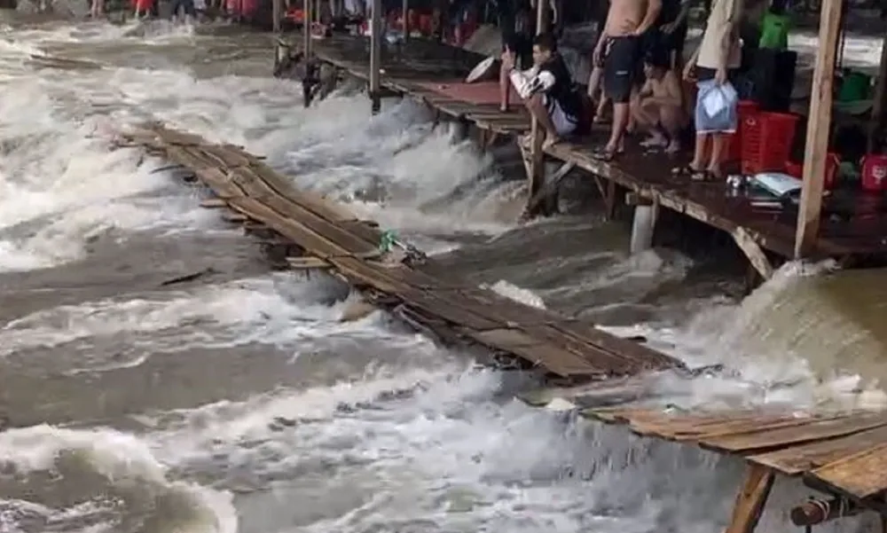 Du khách đứng trên các sạp đợi nước lũ rút. Ảnh: ND