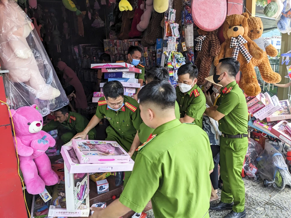 Cán bộ chiến sĩ cùng người dân hỗ trợ hộ gia kinh doanh đưa hàng hóa ra vị trí an toàn. Ảnh: ND