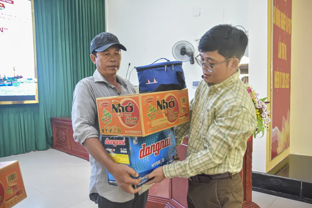 Ông Lê Văn Phi, Trưởng Văn phòng báo Pháp Luật TP.HCM tại Đà Nẵng, trao quà cho ngư dân. Ảnh: NGUYỄN DO