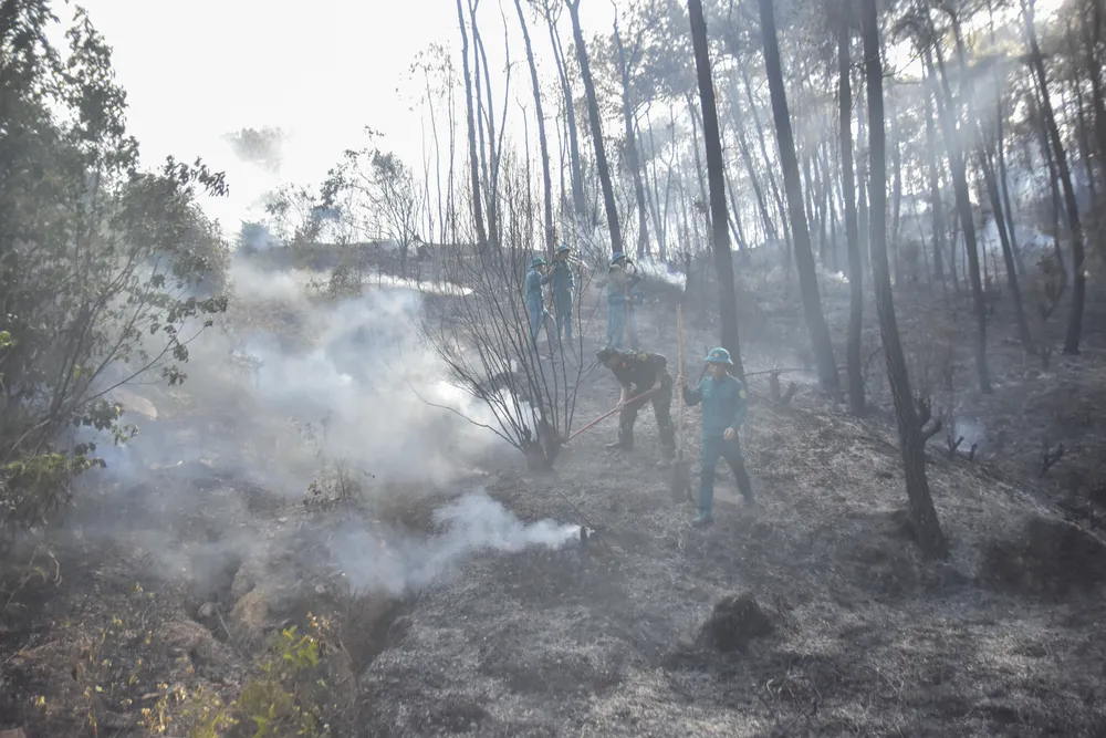 Lực lượng chức năng tham gia dập lửa. Ảnh: NGUYỄN DO