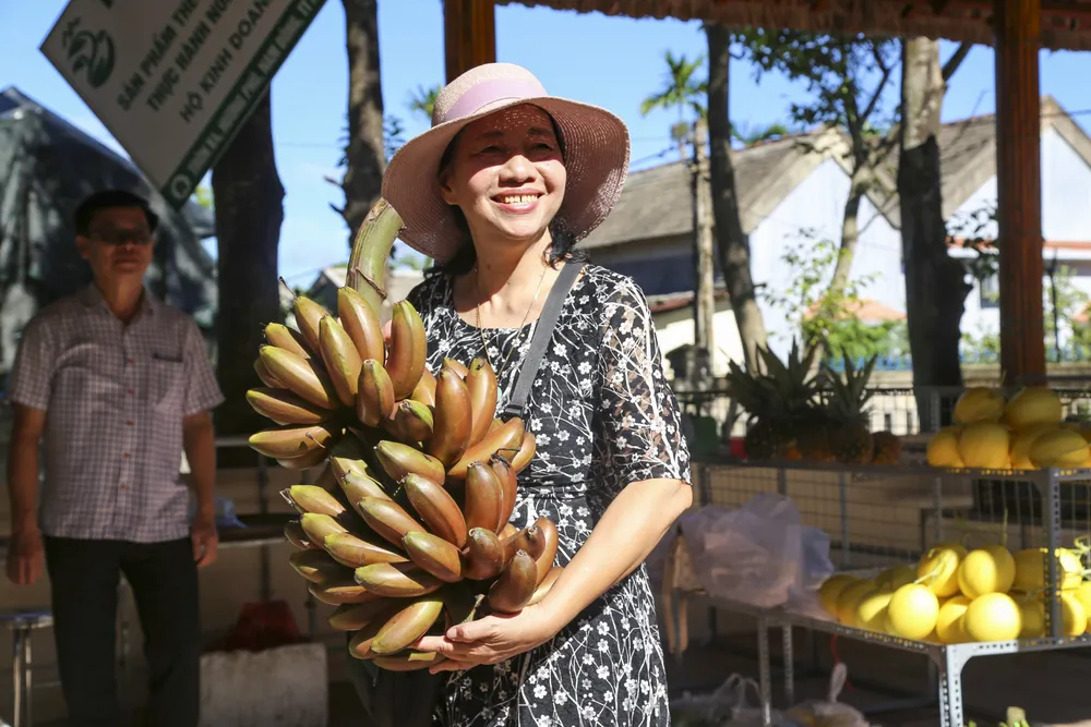 Du khách chọn mua nông sản tại chợ phiên.
