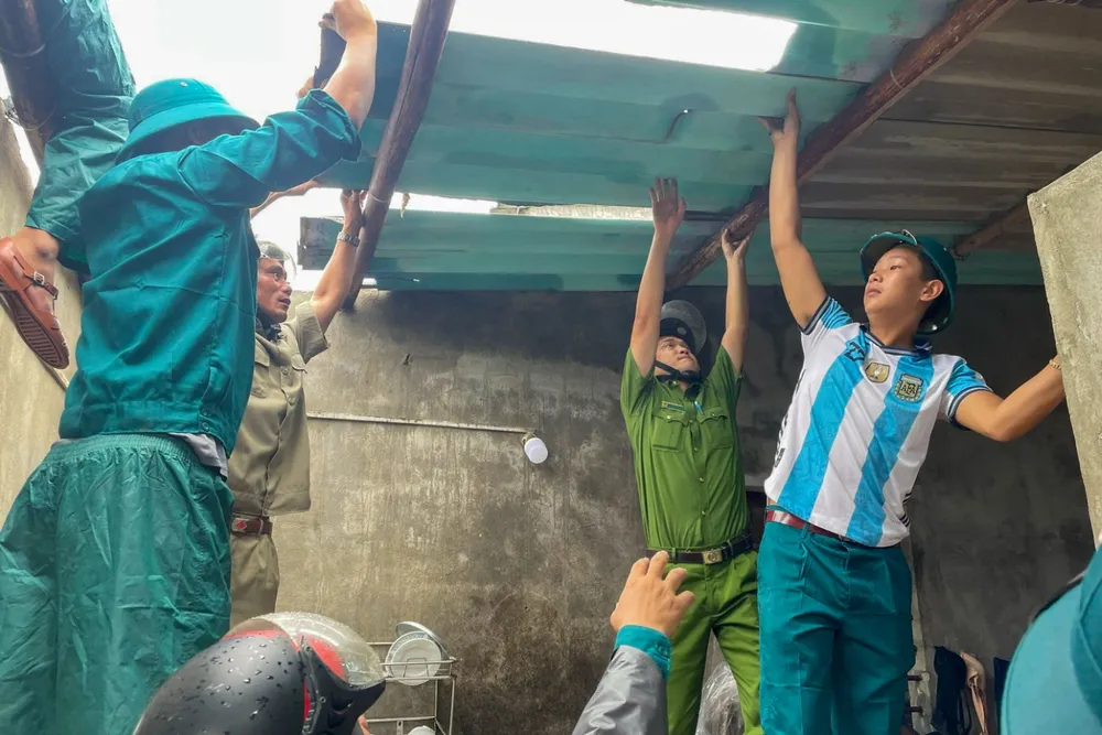 Người dân được cán bộ chiến sĩ hỗ trợ để lợp lại mái tôn. khac-phuc-loc-xoay-9.jpg