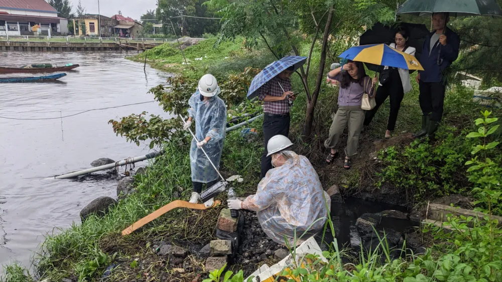 Lực lượng chức năng lấy mẫu nước quan trắc tại vị trí thứ 1. Ảnh: NGUYỄN DO lay-mau-quan-trac