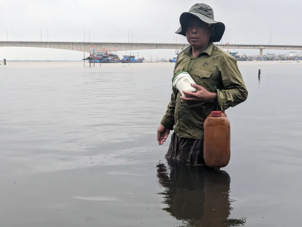 Ông Võ Văn Đức (ở thị trấn Cửa Việt, huyện Gio Linh) phản ánh nước biển ở vị trí cảng Hợp thịnh xả thải có màu đen. Ảnh: NGUYỄN DO nguoi-dan-phan-anh
