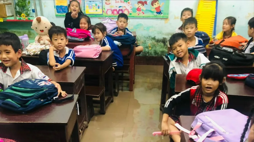 Nước ngập tràn vào lớp học ở tầng 1 Trường Tiểu học Phú Tân. Ảnh: T.P hoc-sinh-nghi-hoc (1).jpg