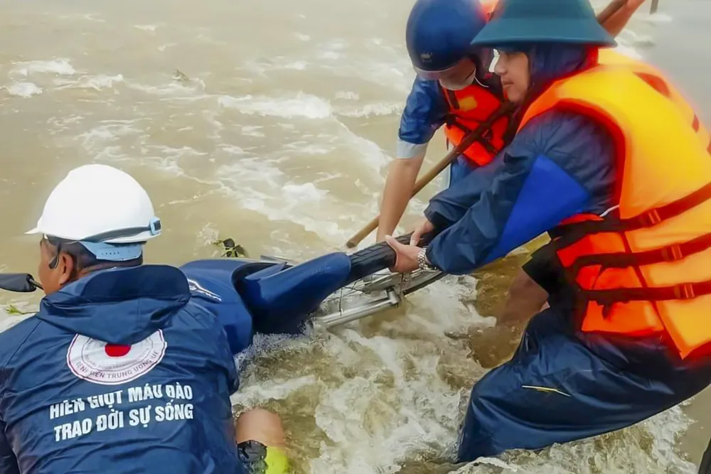Sau khi cứu 2 mẹ con thành công, lực lượng chức năng mất khoảng 2 giờ đồng hồ để đưa xe máy lên bờ. Ảnh: BT cứu hai mẹ con bị nước cuốn