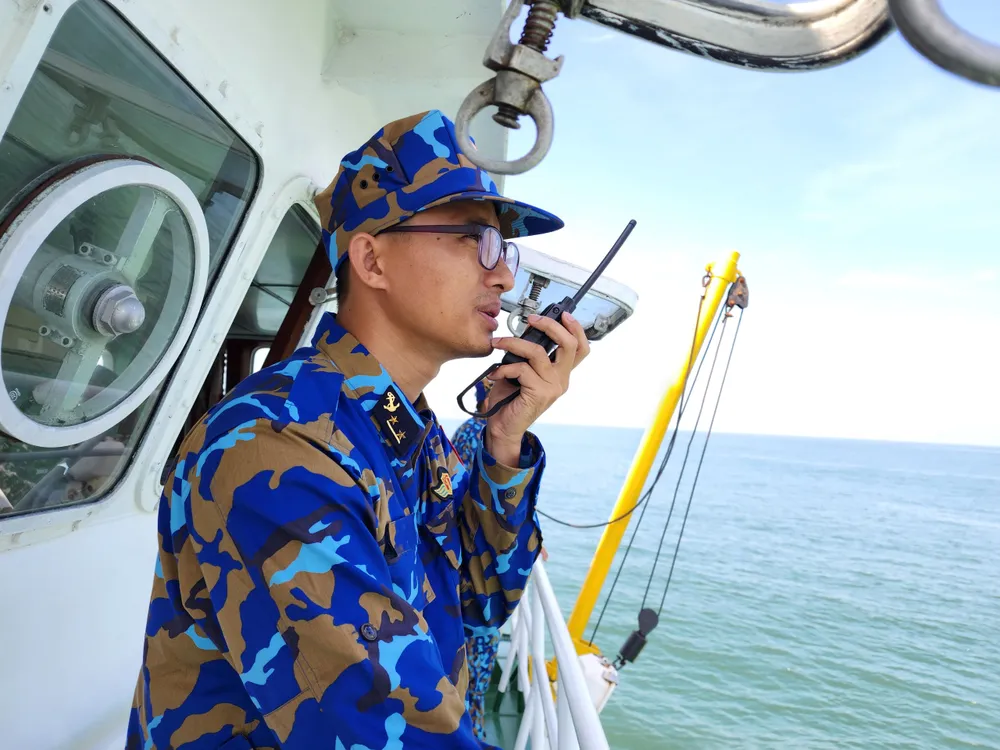Đại úy Ngô Văn Quyền điện đàm hướng dẫn cập mạn tàu 467. Ảnh: MINH TRƯỜNG don-tau-467.jpg