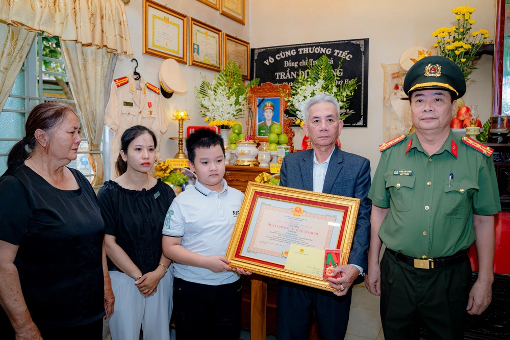 Đại diện gia đình đón nhận Huân chương Bảo vệ Tổ quốc hạng Ba do Chủ tịch nước truy tặng cho Trung tá Trần Duy Hùng - nguyên Phó Công an phường Thủy Vân. Ảnh: TH Phó trưởng công an phường hy sinh