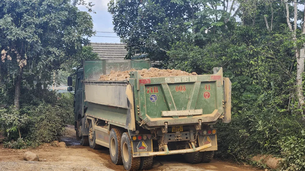 Xe tải chở đất từ mỏ vật liệu san lấp đi qua khu dân cư nhưng không được che bạt. Ảnh: NGUYỄN DO bui-bam-o-cao-toc-cam-lo-van-ninh-8.jpg